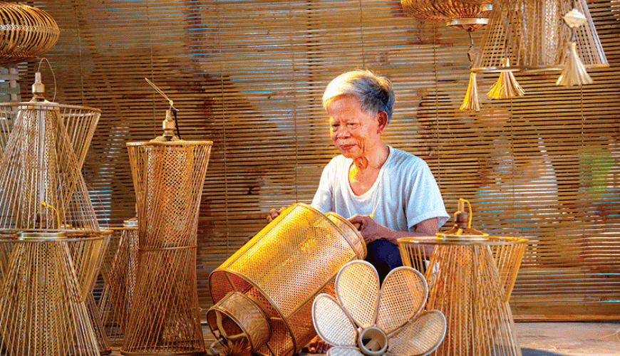Người thợ lớn tuổi kiểm tra và hoàn thiện đèn tre trang trí.
