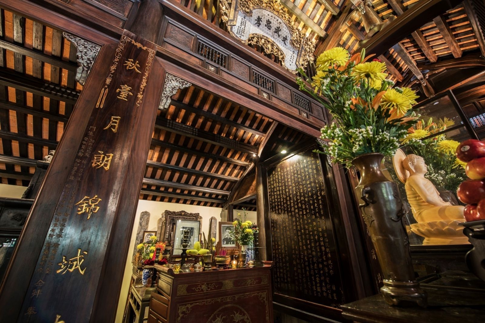 Một chiếc bàn trà cổ điển được đặt bên trong ngôi nhà gỗ, phía sau là cửa sổ nhìn ra khu vườn.