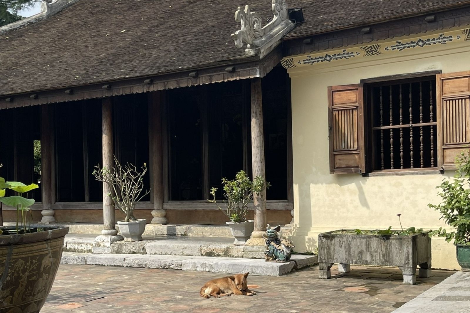 Cổng tam quan cổ kính của Nhà vườn An Hiên với mái ngói cong và các chi tiết chạm khắc tinh xảo.
