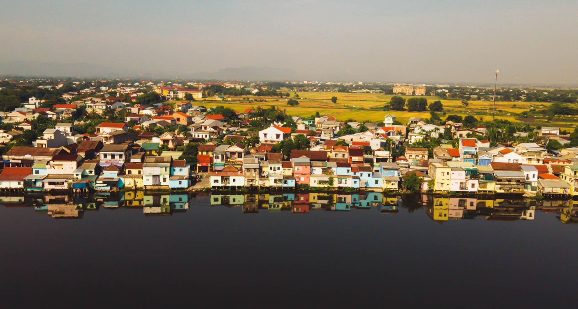 Một con đường lát gạch ở Bao Vinh với một người phụ nữ đi xe đạp, phía sau là những ngôi nhà cổ.