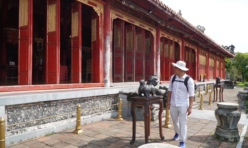 Cận cảnh một góc sân phía trước Thế Tổ Miếu với chiếc đỉnh đồng và tấm biển thông báo.