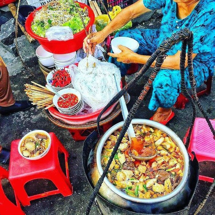 Cận cảnh tô Bún Bò Huế đầy đặn với nước dùng đỏ gạch, thịt bò, giò heo và rau thơm.