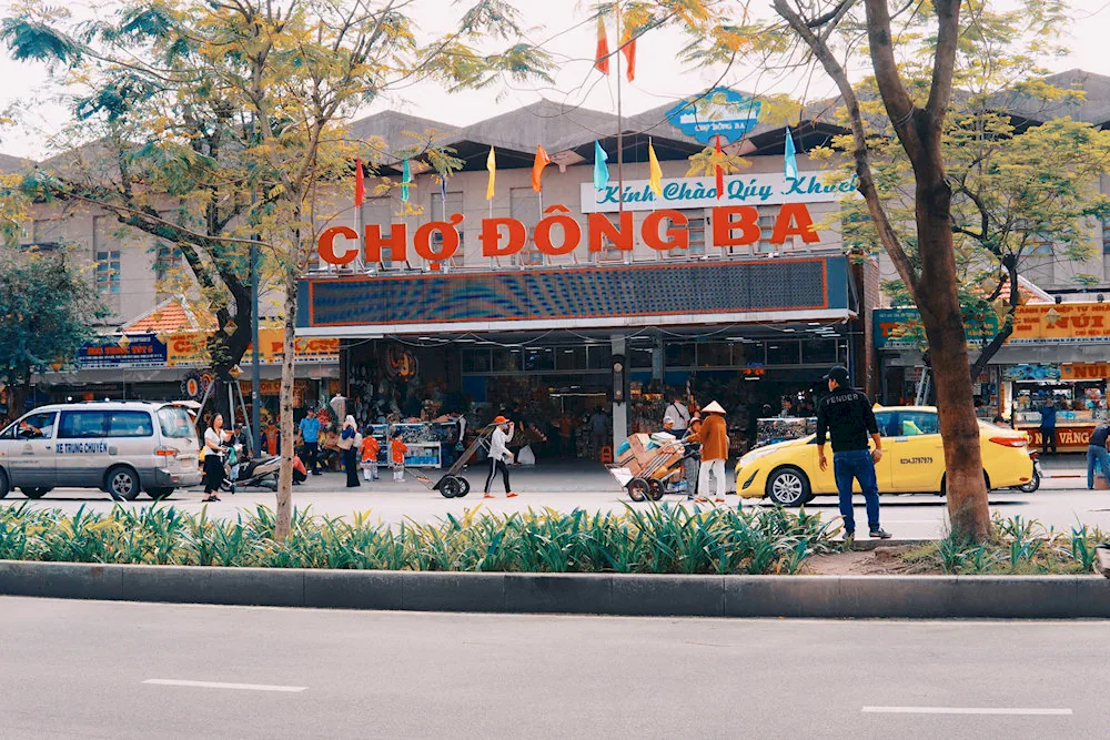Cổng chính của Chợ Đông Ba với kiến trúc cổ kính, đông đúc người qua lại.