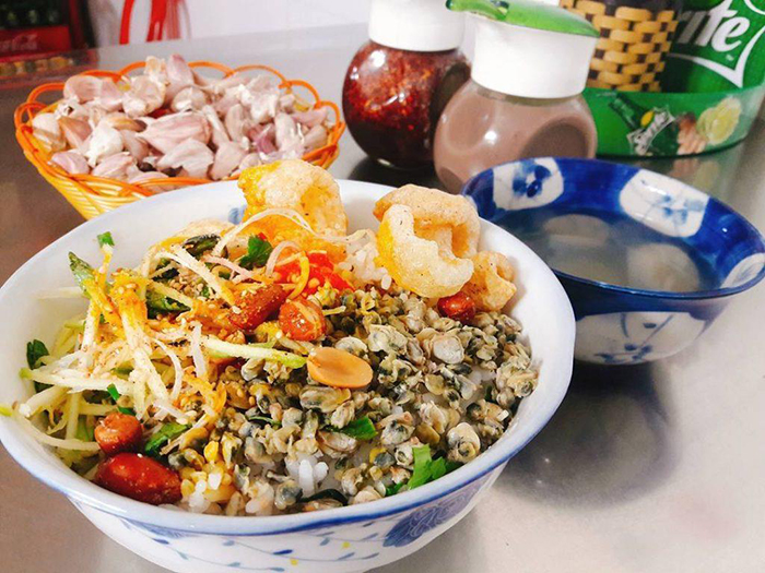 Hai tô Cơm Hến và Bún Hến, đặc sản dân dã của Huế, với đầy đủ các thành phần như hến xào, đậu phộng và tóp mỡ.