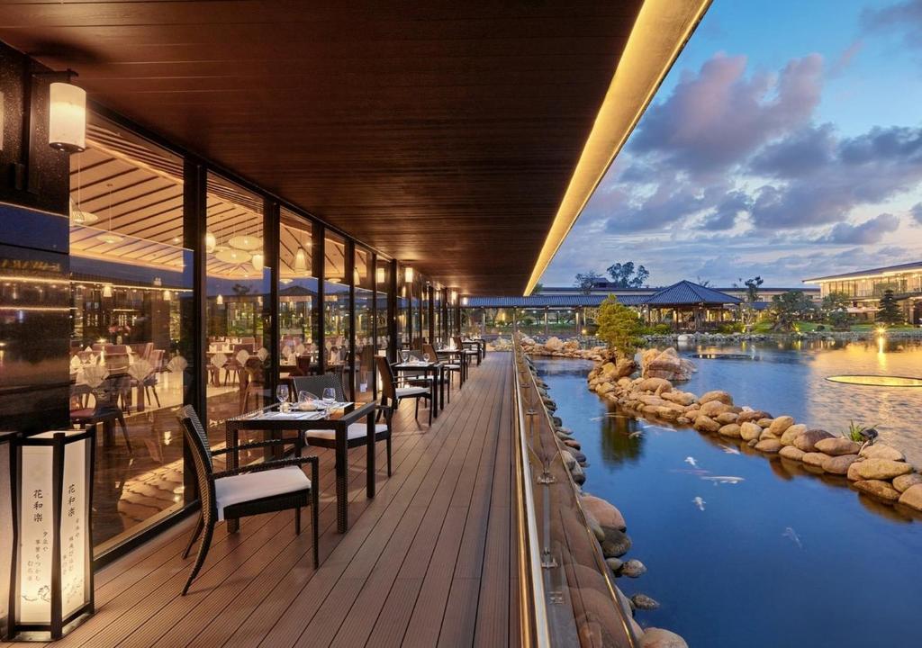 Cận cảnh khu vực hồ tắm Onsen ngoài trời (rotenburo) được bao quanh bởi đá và cây xanh.