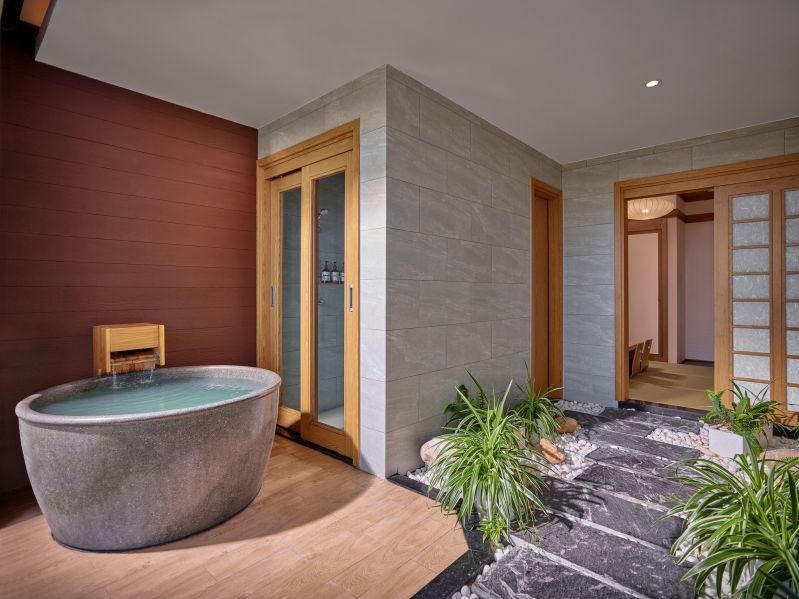 Khu vực nhà hàng hoặc phòng ăn với bàn ghế gỗ và tầm nhìn ra khu vườn hoặc hồ nước.
